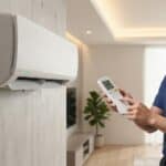 A professional technician extracting a fault code from an indoor Daikin split air conditioner unit using a remote controller in Singapore.